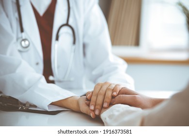 Hands of unknown woman-doctor reassuring her female patient, close-up. Medicine concept