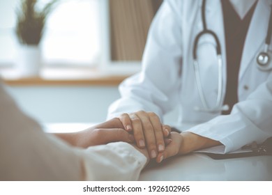 Hände unbekannter Frau-Doktorin beruhigen ihre weibliche Patientin, Nahaufnahme. Medizinkonzept