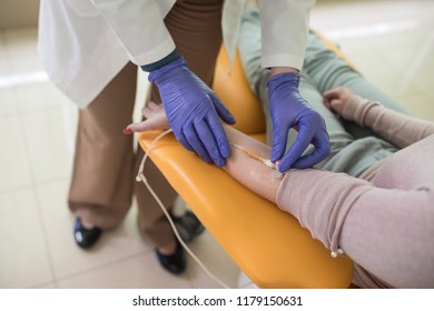 Hands Of Unrecognisable Woman Doctor Giving Infusion Therapy To A Patient.