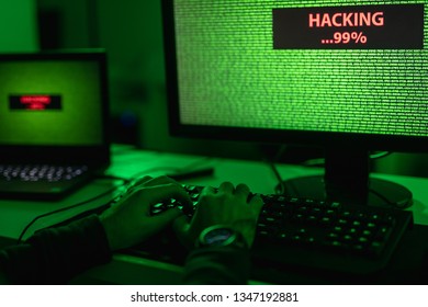 Hands of unrecognizable hacker typing on keyboard while hacking encrypted database in dark room  - Shutterstock ID 1347192881