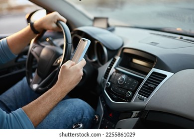 Hands of unrecognizable man driver using mobile phone while driving - Powered by Shutterstock