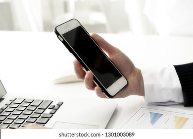 Hands are using a blank screen smartphone.