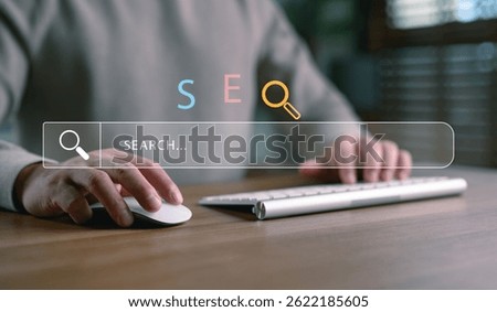 Hands using computer with SEO and search bar interface, representing search engine optimization, keyword research, online visibility, website ranking, digital marketing and web traffic strategy.