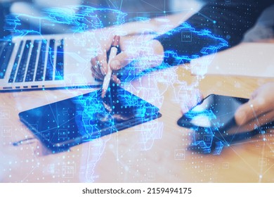hands using digital tablet with pen and smartphone with glowing blue map hologram and digital data concept on blurry office desktop background. Info, news and planet concept. Double exposure
