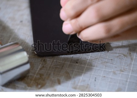 Hands Using Four Prong Pricking Iron on Leather