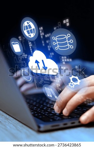 Hands using a laptop with cloud computing icons in a dark setting