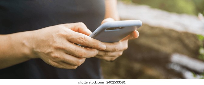 Hands using mobile phone  in summer forest - Powered by Shutterstock