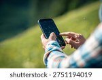 Hands using mobile phone taking picture in summer nature