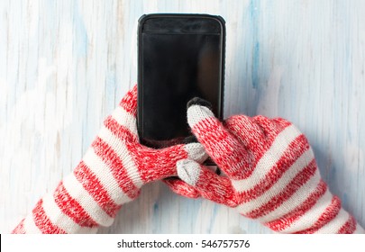 Hands Using Smart Phone In Winter Gloves