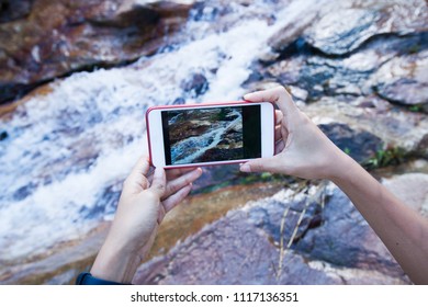Hand's using smartphone over waterfall background,Conceptal technology for environment with copy space.