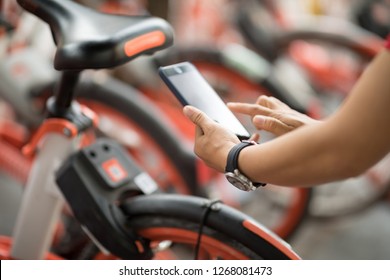 Hands Using Smartphone Scanning The QR Code Of Shared Bike In City 