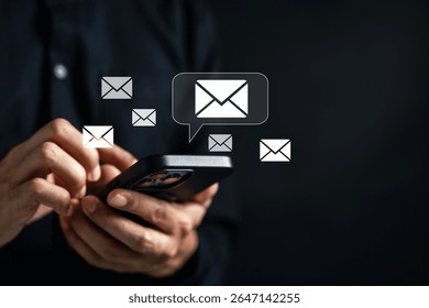 Hands using smartphone to send and read emails with envelope icons. Mobile communication, email marketing, and digital messaging technology for business and personal use...
