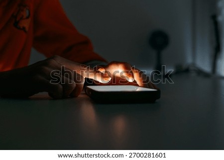 Hands using smartphone touchscreen in low light