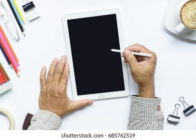 Hands using tablet computer with coffee cup and color pencil etc on isolated.Top view.