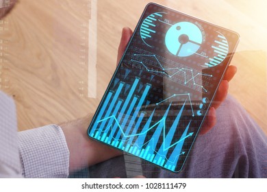 Hands using tablet with digital business chart on screen. Device and finance concept. Double exposure 