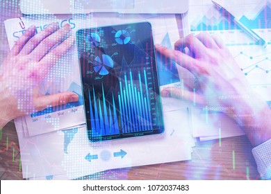 Hands using tablet with forex chart placed on office desk with other items. Accounting, finance and market concept. Double exposure 