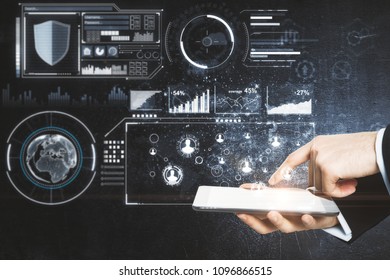 Hands using tablet with glowing digital business interface on concrete wall background. Innovation and future concept 