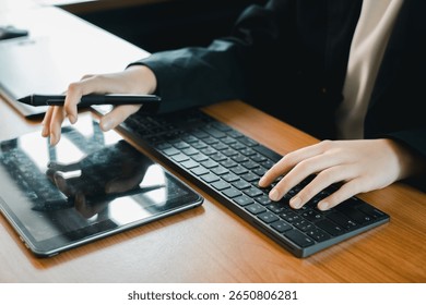Hands using a tablet and keyboard, ideal for digital design, creativity, and modern office work settings.