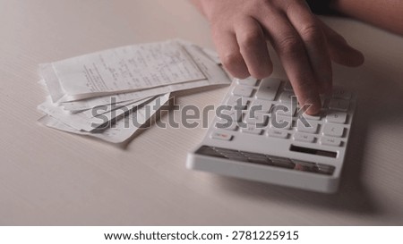 Hands Using White Calculator With Receipts, Freelancer Tracking Expenses On Cluttered Desk, Pen And Notepad Nearby, Handwritten Totals On Paper, Soft Warm Lighting, Focused Determination, Latenight