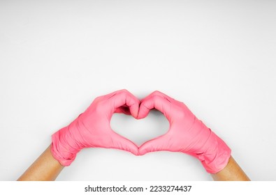 Hands in viva magenta color heart-shaped medecine gloves concept 2023 - Shutterstock ID 2233274437