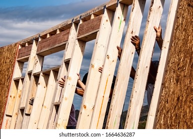 Hands of volunteers raising a wall for a Habitat for Humanity home - Shutterstock ID 1664636287