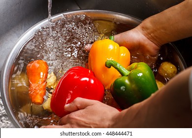 Hands Wash Paprika And Carrot. Vegetables With Water In Basin. Vegetarian Food In Restaurant Kitchen. First Step Of Cooking Meals.