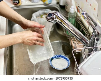 Hands To Wash Plastic Storage Containers With Water