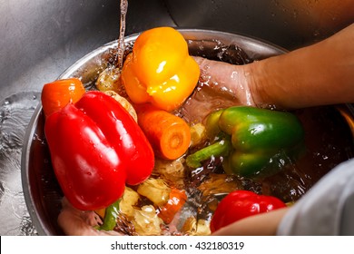 Hands wash vegetables in basin. Red paprika and carrot. Live a healthy life. No pesticides or chemicals. - Powered by Shutterstock