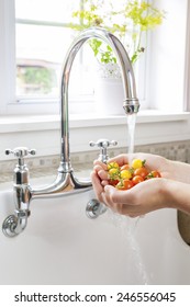 Hands Washing Fresh Cherry Tomatoes In Running Water Of Kitchen Sink With Curved Faucet
