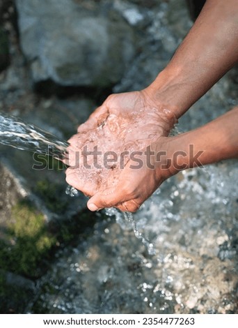 Hands, water splash and washing in nature outdoor. Man scoops up water with his hands to drink. Fresh cold, potable water of mountain spring. Health and wellness for hydration and ecology concept