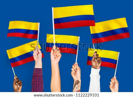 Hands waving the flags of Columbia