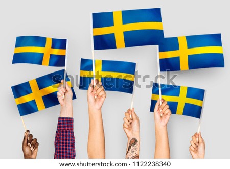 Hands waving the flags of Sweden