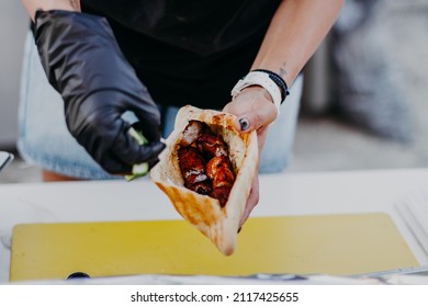 Hands Wear Black Vinyl Gloves Making Gyros Shawarma For Take Away. Fast Food Sandwich With Vegetables And Meat. Close Up Image With Selective Focus