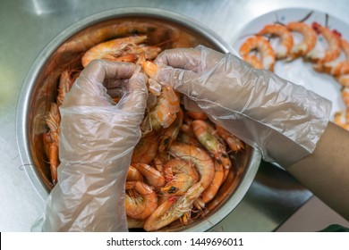 Hands Wearing Disposable Plastic Gloves And Peeling Steamed Shrimp