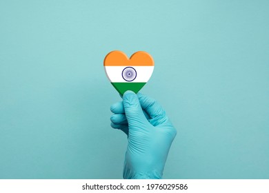 Hands wearing protective surgical gloves holding India flag heart - Powered by Shutterstock