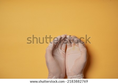 Hands wearing white medical groves on yellow background. Health, medical, protection, hygiene, clean, safety concept. Copy space for text.