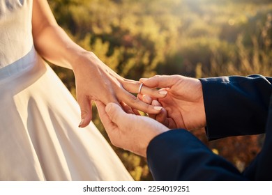 Hands, wedding couple and ring at ceremony outdoor with jewelry and save the date announcement. Engagement, love together and marriage of people in nature at life commitment and engagement event