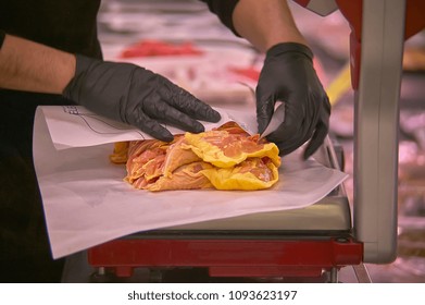 Hands weighing chicken meat on a scales at the meat department of a supermarket. - Powered by Shutterstock