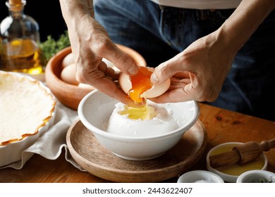 Hands while cracking an egg into the cheese mixture while preparing the pastry - Powered by Shutterstock