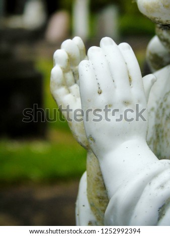 Hands of a white statue in an almost prating position