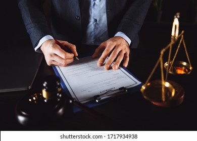 Hands of wife, husband signing decree of divorce, dissolution, canceling marriage, legal separation documents, filing divorce papers or premarital agreement prepared by lawyer. Wedding ring - Shutterstock ID 1717934938