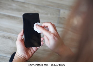 Hands Wiping Down Mobile Phone’s Surfaces Due To Corona Virus Crisis.