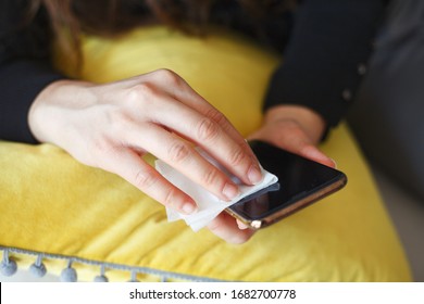 Hands Wiping Down Mobile Phone’s Surfaces Due To Corona Virus Crisis.