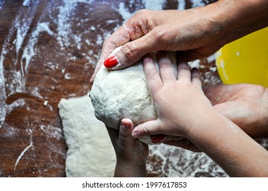 Hands Of A Woman And A Child Kneading Dough