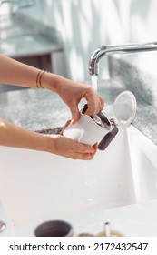 Hands Of A Woman Cleaning The Parts Of A Moka Coffee Maker Under A Stream Of Water