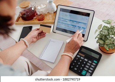 Hands of woman with credit card using application on tablet computer when paying utility bills