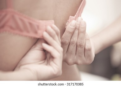 Hands of woman dressing pink brassiere - Shutterstock ID 317170385