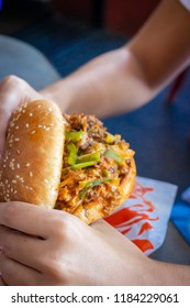 Hands Of Woman Eating Sloppy Burger.