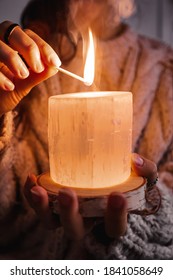 Hands Of A Woman Holding And Lighting A Candle