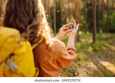 Hands of woman holding navigational compass. Female traveler holding compass in hands and navigating in nature. The concept of hiking, nature. - Powered by Shutterstock